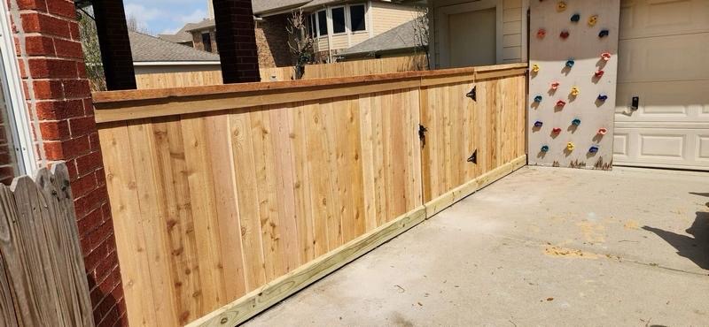 Cedar privacy fence with gate along a driveway