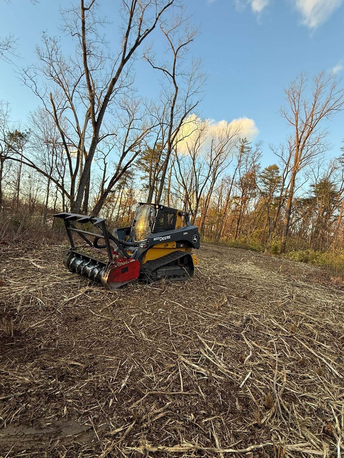 Forestry mulcher clearing brush and underwood on a wooded hillside